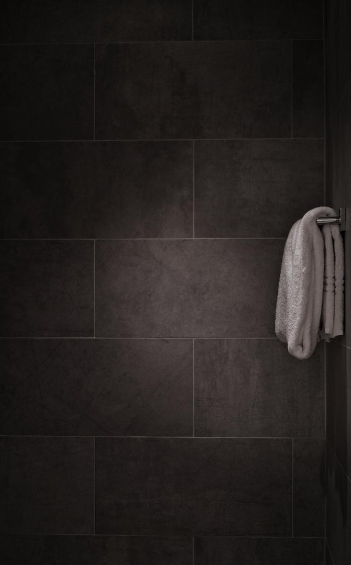 Khăn tắm treo gọn trên thanh inox trong phòng tắm lát gạch
